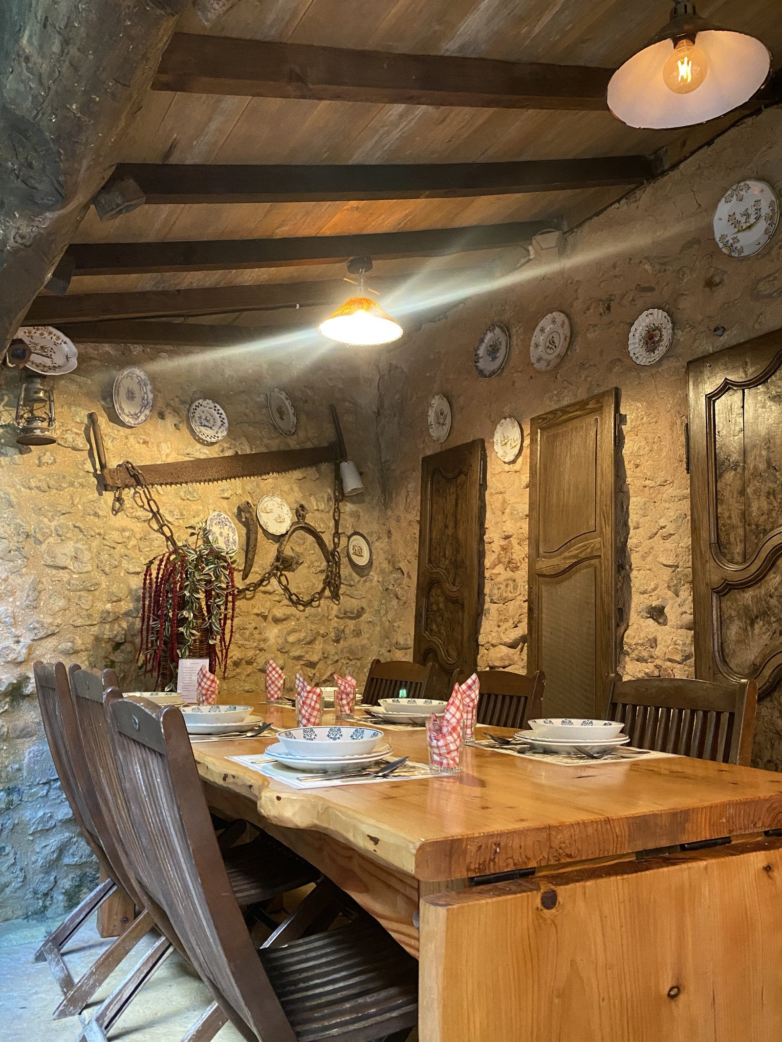 Le mur de pierre de la salle, garni d’assiettes anciennes.